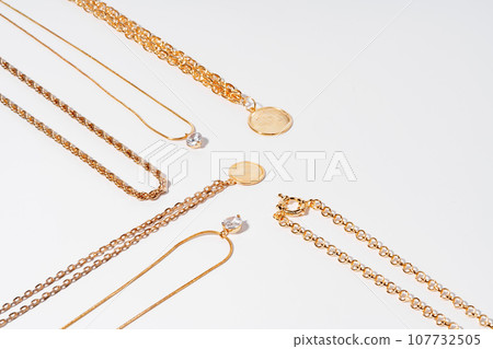 Set of gold chains with pendant on white background 107732505