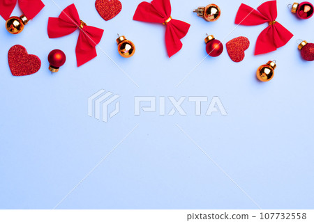 Winter festive background with hearts, bows and baubles Winter festive background with hearts, bows and baubles 107732558