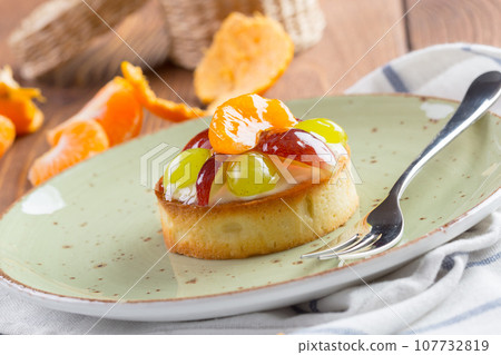 Tart with fruits topping on green plate 107732819