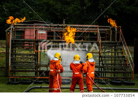 Firefighter Concept. Fireman using water and extinguisher to fighting with fire flame. Firefighter Concept. Fireman using water and extinguisher to fighting with fire flame. 107733854