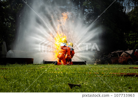 Firefighter Concept. Fireman using water and extinguisher to fighting with fire flame. Firefighter Concept. Fireman using water and extinguisher to fighting with fire flame. 107733963