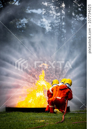 Firefighter Concept. Fireman using water and extinguisher to fighting with fire flame. Firefighter Concept. Fireman using water and extinguisher to fighting with fire flame. 107734025