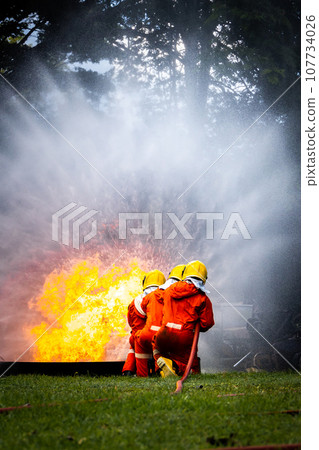 Firefighter Concept. Fireman using water and extinguisher to fighting with fire flame. 107734026