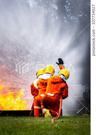 Firefighter Concept. Fireman using water and extinguisher to fighting with fire flame. Firefighter Concept. Fireman using water and extinguisher to fighting with fire flame. 107734027