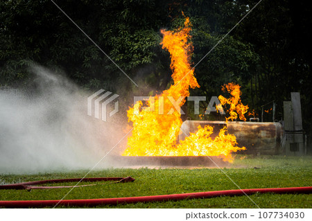 Firefighter Concept. Fireman using water and extinguisher to fighting with fire flame. Firefighter Concept. Fireman using water and extinguisher to fighting with fire flame. 107734030