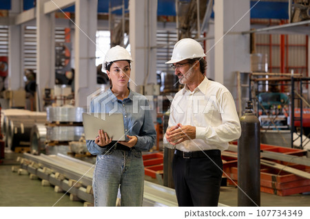 Factory manager or executive with his assistant visit factory tour. Exemplifying Factory manager or executive with his assistant visit factory tour. Exemplifying 107734349