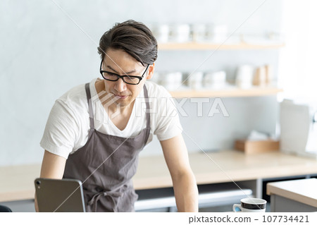 Cafe clerk using a tablet Cafe clerk using a tablet 107734421