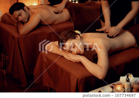 Hot stone massage at spa salon in luxury resort with warm candle light.Quiescent Hot stone massage at spa salon in luxury resort with warm candle light.Quiescent 107734697