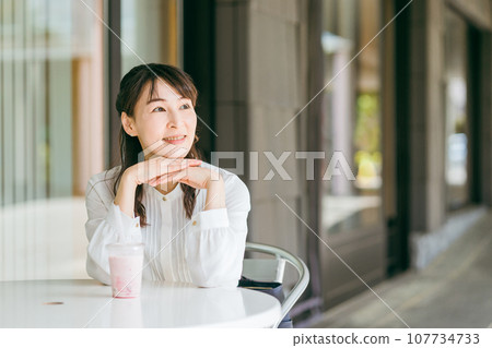 Asian business woman drinking smoothie/shake/protein/ferment at a cafe (break/lunch break/lunch) 107734733