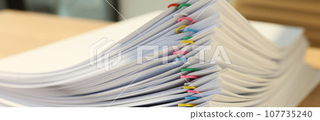 Stack of papers fastened with pins lies on wooden table Stack of papers fastened with pins lies on wooden table 107735240