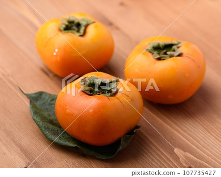 Very sweet taste of autumn Persimmon Fruit (Wood grain background) Persimmon fruit Very sweet taste of autumn Persimmon Fruit (Wood grain background) Persimmon fruit 107735427