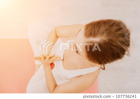 Two young sporty woman, fitness instructor in sportswear doing stretching and pilates on yoga mat in the studio with mirror. Female fitness yoga routine concept. Healthy lifestyle and harmony. 107736241