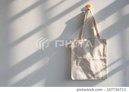 Textile shopping bag hanging from hook. Textile shopping bag hanging from hook. 107736713