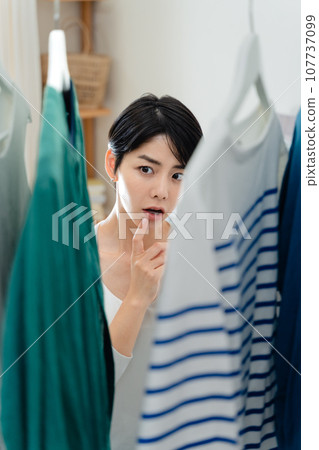 一個女人在她的房間裡準備出去 107737099