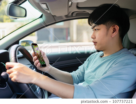 A man looking at the navigation on his smartphone in a car - AI-generated image A man looking at the navigation on his smartphone in a car - AI-generated image 107737221