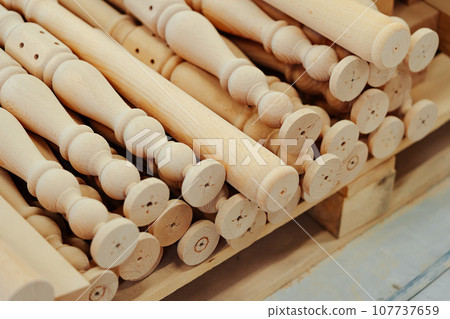 Wooden baluster stacked on the floor in woodwork workshop 107737659