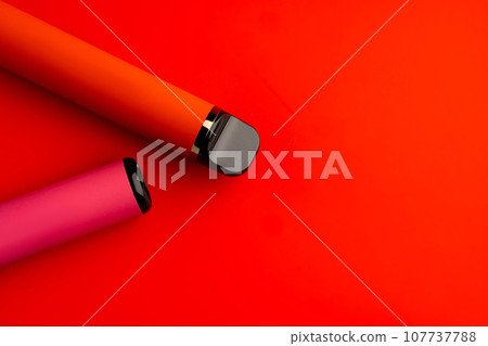 Disposable electronic cigarettes on red background close up Disposable electronic cigarettes on red background close up 107737788
