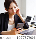 A woman who is tired from operating a computer and smartphone at the same time. electronic device neurosis 107737984