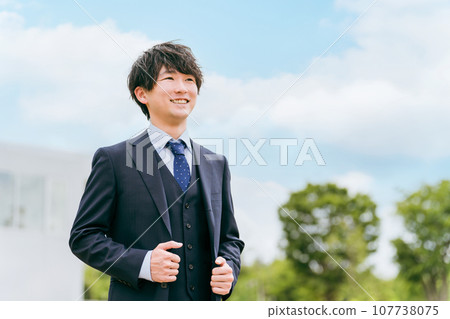 Young Asian businessman standing in front of office with blue sky Young Asian businessman standing in front of office with blue sky 107738075