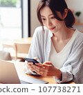 A career woman who operates a smartphone and a computer at the same time. A working Japanese woman with long hair. 107738271