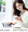 A career woman who operates a smartphone and a computer at the same time. A working Japanese woman with long hair. 107738272
