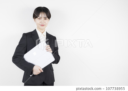 Smiling woman in her 20s holding a laptop Smiling woman in her 20s holding a laptop 107738955