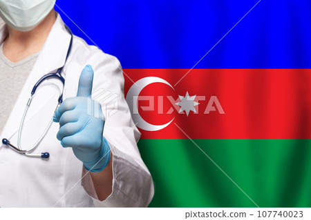 Azerbaijani doctor's hand showing thumb up positive gesture on flag of Azerbaijan background Azerbaijani doctor's hand showing thumb up positive gesture on flag of Azerbaijan background 107740023