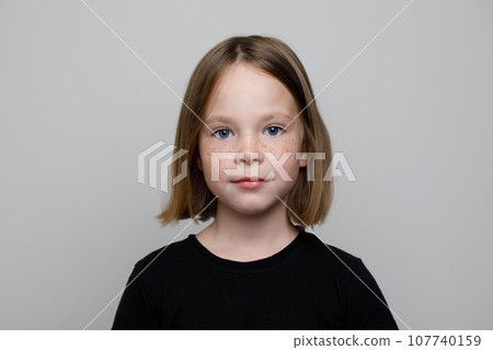 Close up head shot portrait of little brown-haired child girl. Cheerful kid  107740159
