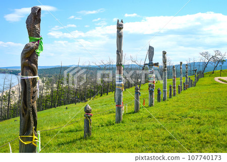 Fence made of wooden hitching posts with ribbons of shamanism religion in Khuzhir, island Olkhon. Fence made of wooden hitching posts with ribbons of shamanism religion in Khuzhir, island Olkhon. 107740173