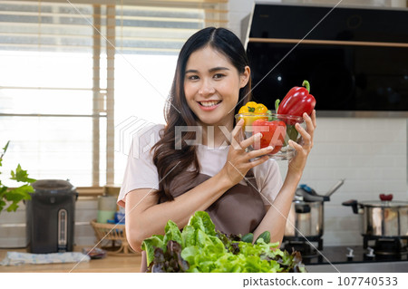 Woman holding vegetables for cooking meal. 107740533