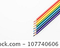 Rainbow color pencils in the form of an arrow from the right corner top view 107740606