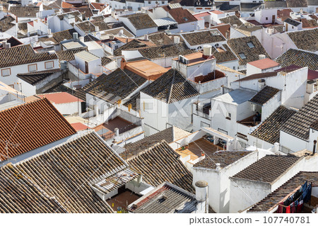 Aerial panoramic view of rooftops of white houses of Olvera town, considered the gate of white towns route in the province of Cadiz, Spain. 107740781