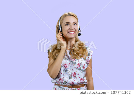 Portrait of happy cheerful female customer support operator wearing headset. Isolated on purple. Portrait of happy cheerful female customer support operator wearing headset. Isolated on purple. 107741362