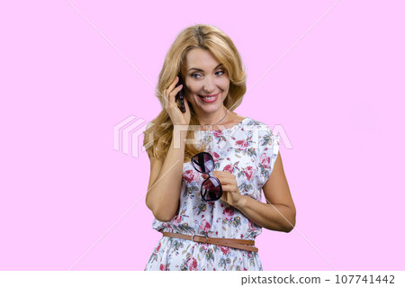 Portrait of happy mature woman talking on the phone. Isolated on pink. Portrait of happy mature woman talking on the phone. Isolated on pink. 107741442