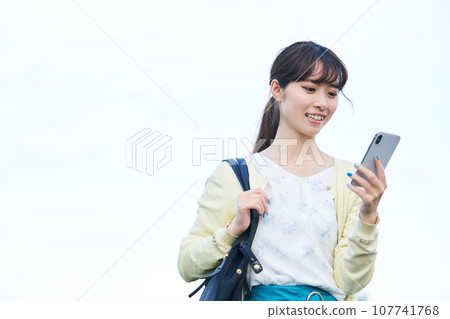 年輕女子藍天智慧型手機 107741768