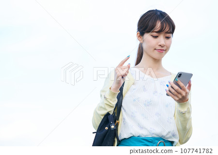年輕女子藍天智慧型手機 107741782