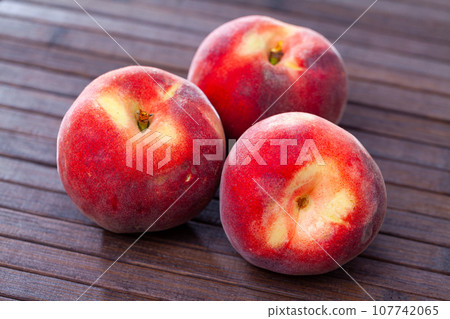 Whole and half fresh red peaches on wooden table. Whole and half fresh red peaches on wooden table. 107742065
