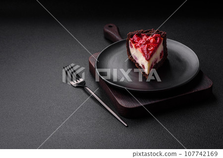 Beautiful tasty sweet slice of cheesecake with cherry on a ceramic plate Beautiful tasty sweet slice of cheesecake with cherry on a ceramic plate 107742169