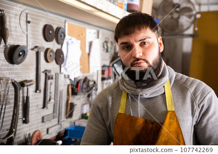 Professional man worker during work with steel in workshop 107742269