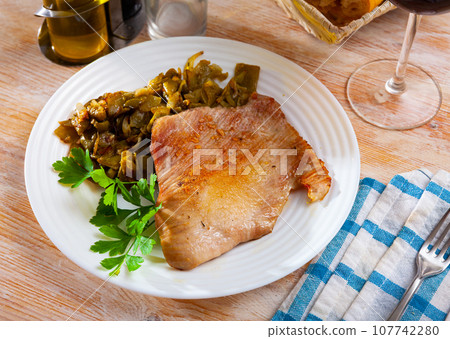 Tasty fried pork chops with stewed beans served 107742280