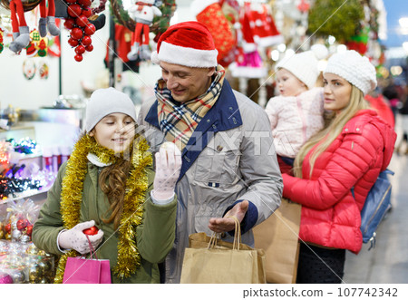 Man and teenage daughter choosing Christmas toys 107742342
