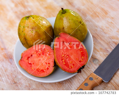 Fresh whole and sliced guava fruits on wooden table Fresh whole and sliced guava fruits on wooden table 107742783