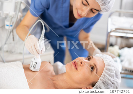 Female patient receiving hardware procedure on chest and neck area using cooling attachment Female patient receiving hardware procedure on chest and neck area using cooling attachment 107742791