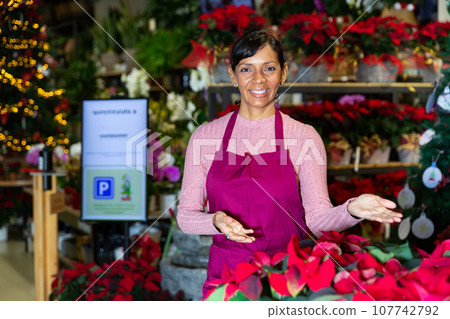 Portrait of a latin american woman florist standing in a store with flowers Portrait of a latin american woman florist standing in a store with flowers 107742792