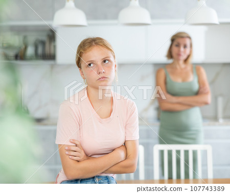 Blurry mum and girl crossed arms and standing apart from each other, ignore do not talk 107743389