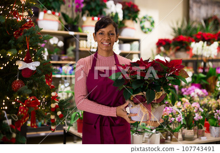 Female home plants store worker with plant Female home plants store worker with plant 107743491