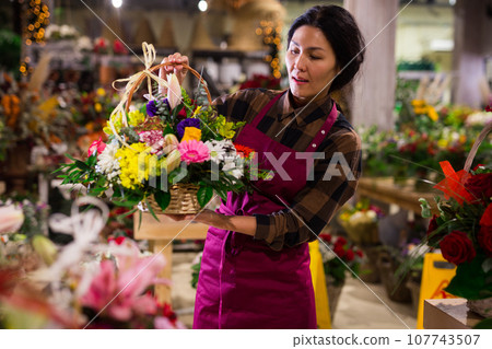 Woman flower seller prepares a luxury bouquet Woman flower seller prepares a luxury bouquet 107743507