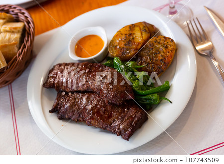 Grilled beef fillet with baked potato, green peppers and chimichurri sauce Grilled beef fillet with baked potato, green peppers and chimichurri sauce 107743509