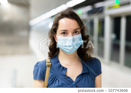 Woman in personal protective equipment at metro station Woman in personal protective equipment at metro station 107743606