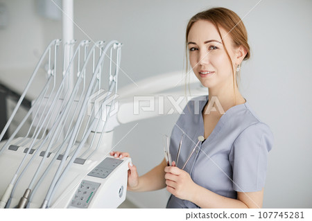 Image of a beautiful happy young woman doctor in medical dentist center. 107745281